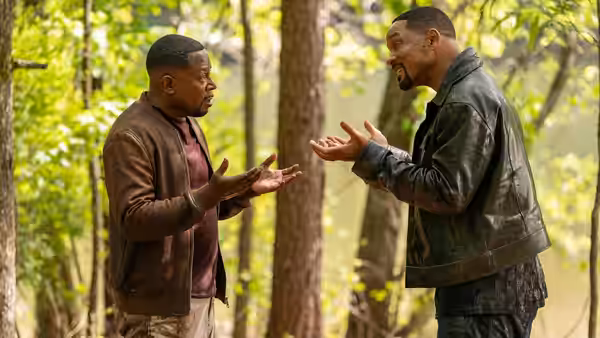Mike Lowrey (Will Smith) and Marcus Burnett (Martin Lawrence) arguing with raised hands in the woods