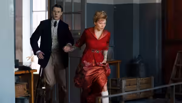 Gabrielle (Léa Seydoux) in a red dress pulling Louis (George MacKay) by the hand