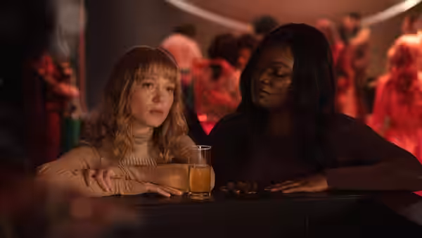 Gabrielle (Léa Seydoux) and Poupée Kelly (Guslagie Malanda) seated together at a bar