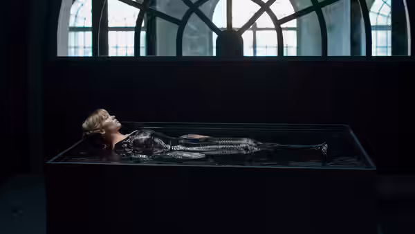 Gabrielle (Léa Seydoux) floating on her back inside a water-filled rectangular tank