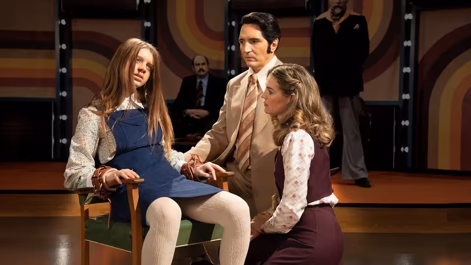 Lilly D'Abo (Ingrid Torelli) bound to a chair as June Ross-Mitchell (Laura Gordon) and Jack Delroy (David Dastmalchian) attend to her