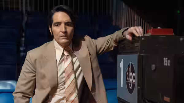 Jack Delroy (David Dastmalchian) rests his arm on broadcast equipment inside an empty auditorium
