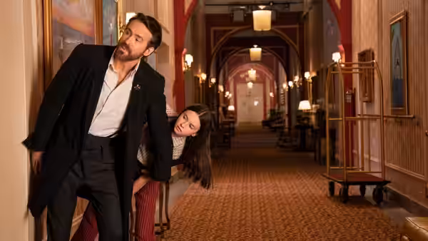 Cal (Ryan Reynolds) and Bea (Cailey Fleming) hide in a hotel hallway