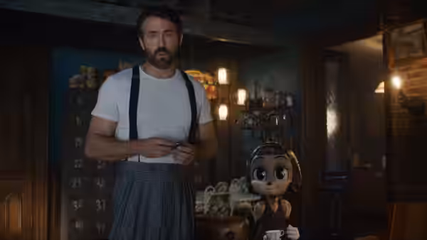 Cal (Ryan Reynolds) stands beside a small imaginary friend in a workshop