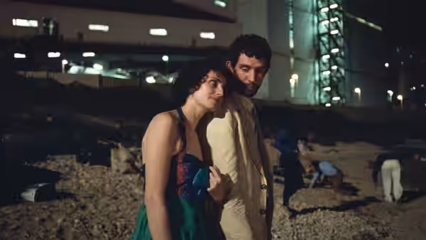 Arthur (Josh O'Connor) standing close with a woman on rocky ground at night