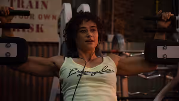 Jackie (Katy O'Brian) working out on a chest press machine in a gym