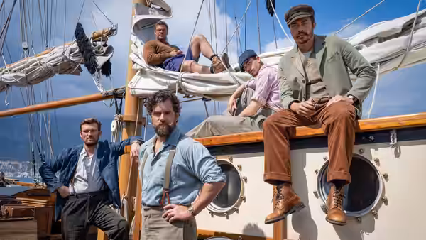 Group of men pose together on the deck of a sailing ship