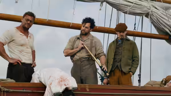 Three men stand over a bloodied body on a wooden ship deck