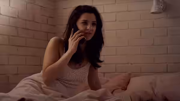 Amy (Marisa Abela) talking on the phone while sitting in bed