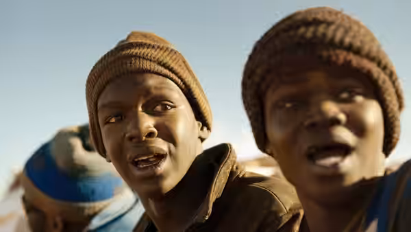 two young men in beanies looking ahead outdoors