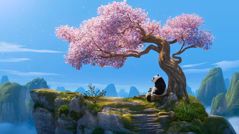 Po (Jack Black) sits under a large pink-blossomed tree on a mountain cliff