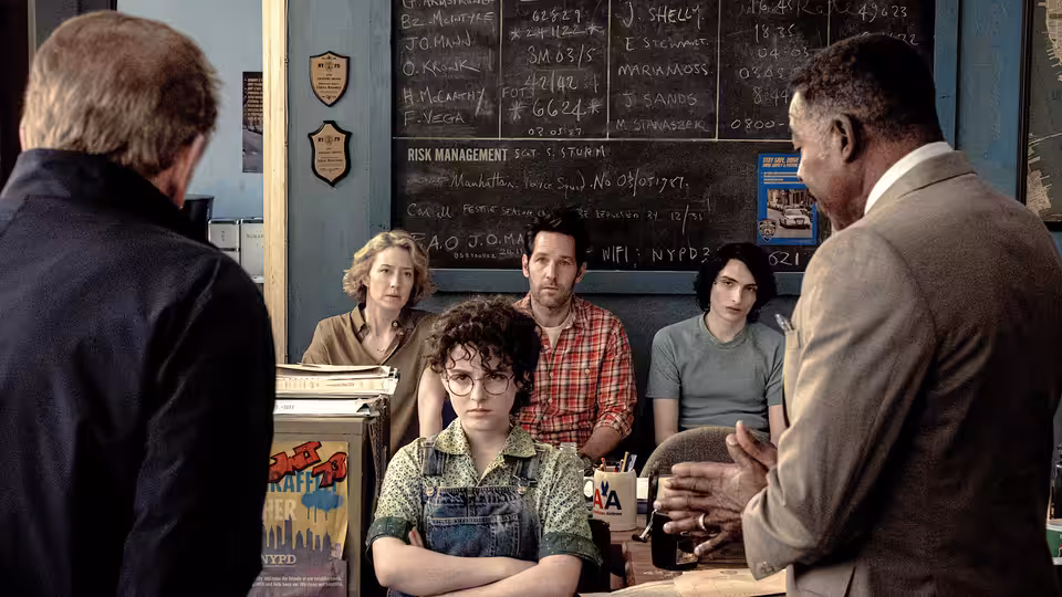 Phoebe Spengler (Mckenna Grace) sits with crossed arms during a meeting with adults