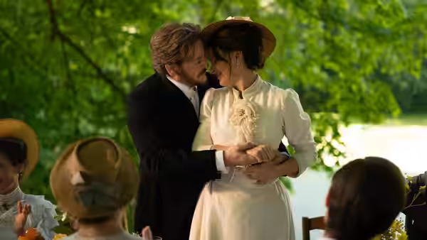 Dodin Bouffant (Benoît Magimel) and Eugénie (Juliette Binoche) embracing closely outdoors at a gathering