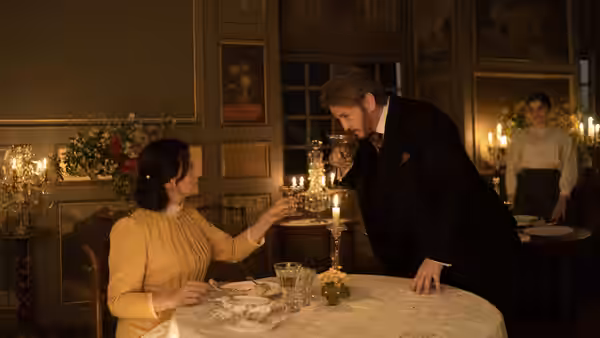 Dodin Bouffant (Benoît Magimel) leaning toward a woman in yellow at a formal dinner