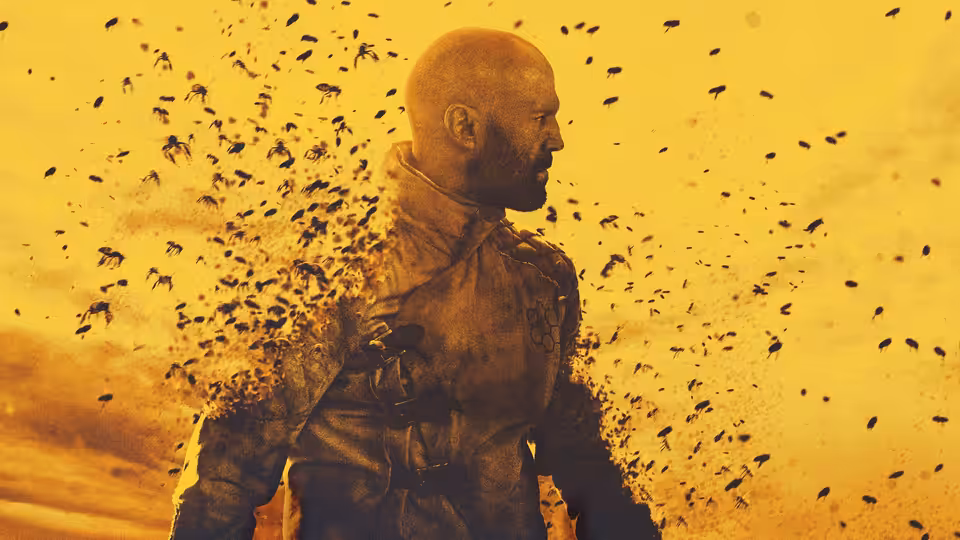 Adam Clay (Jason Statham) standing amid a swarm of bees in a yellow sky