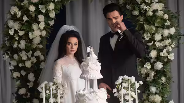 Priscilla (Cailee Spaeny) and Elvis (Jacob Elordi) beside a tiered wedding cake