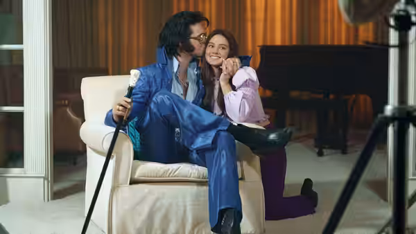 Elvis (Jacob Elordi) and Priscilla (Cailee Spaeny) posing together in a studio