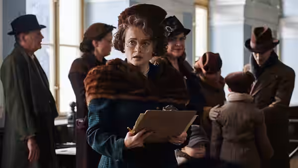 Doreen Warriner (Romola Garai) holding a clipboard on a station platform