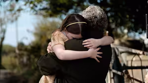 Cáit (Catherine Clinch) embraces Seán (Andrew Bennett) beneath a tree