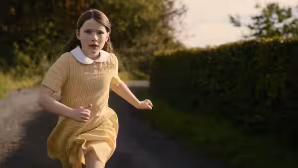 Cáit (Catherine Clinch) runs down a country lane in a yellow dress