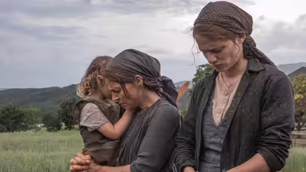 Fani Jägerstätter (Valerie Pachner) holding a child beside another woman outdoors