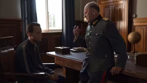 Franz Jägerstätter (August Diehl) seated before an officer in a military office