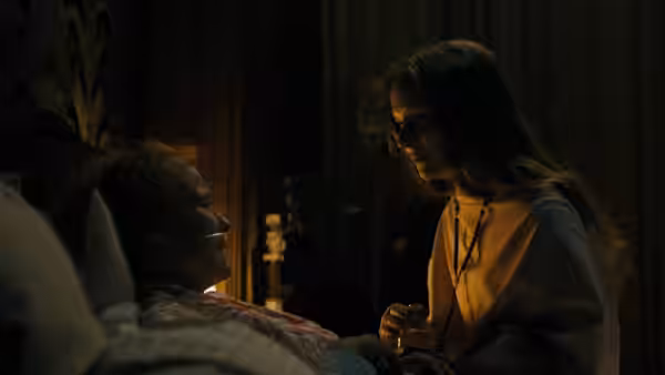 Maud (Morfydd Clark) holds Amanda’s hand beside her bed