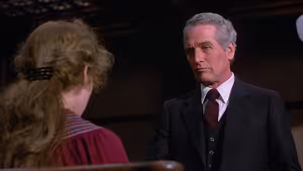 Frank Galvin (Paul Newman) facing a woman with her back turned in a room