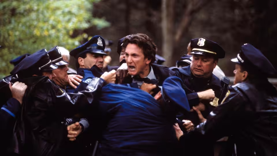Jimmy Markum (Sean Penn) restrained by police officers in the street