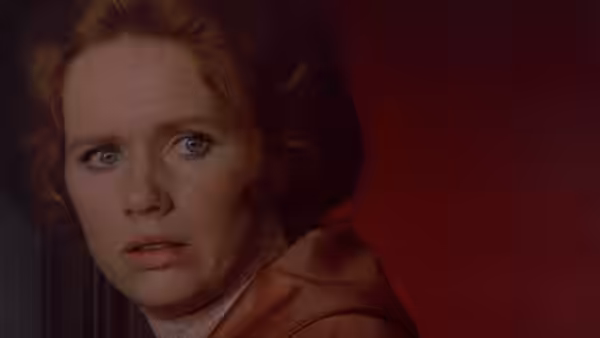 a red-haired woman turns with a concerned expression on her face