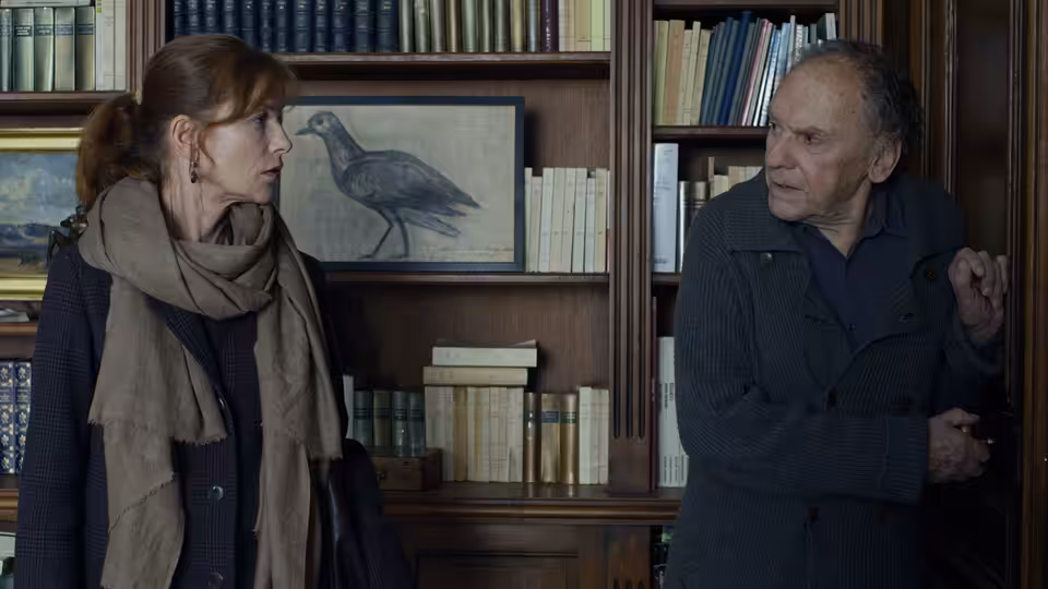 Eva (Isabelle Huppert) facing Georges (Jean-Louis Trintignant) in the book-lined study