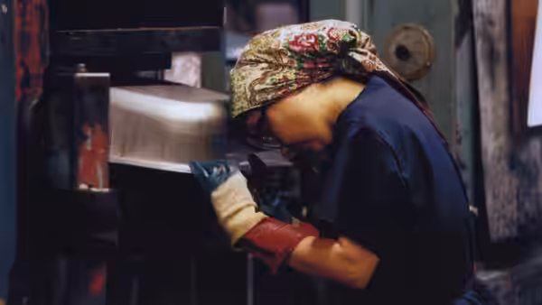 Selma Jezkova (Björk) operating heavy machinery inside a factory