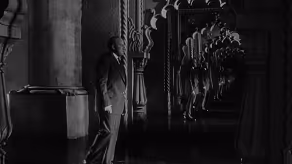 Charles Foster Kane (Orson Welles) standing in an ornate empty hall
