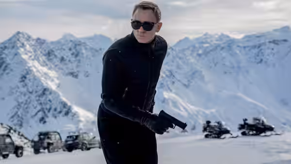 James Bond (Daniel Craig) holding a gun in a snowy mountain landscape