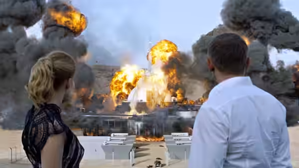 Madeleine (Léa Seydoux) and a man watching massive fiery explosions