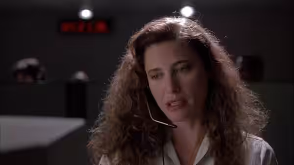 Sharon wears a headset and speaks at a telephone counseling desk