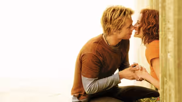 Jerry (Brad Pitt) and Samantha (Julia Roberts) sit close holding hands face to face