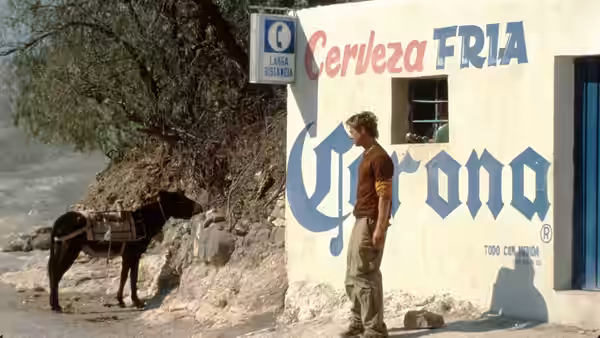 Jerry (Brad Pitt) stands beside a wall painted with Corona beer logos