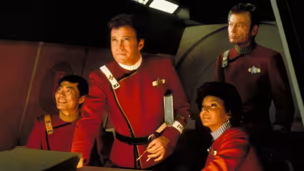 Kirk (William Shatner) standing with three officers on the bridge