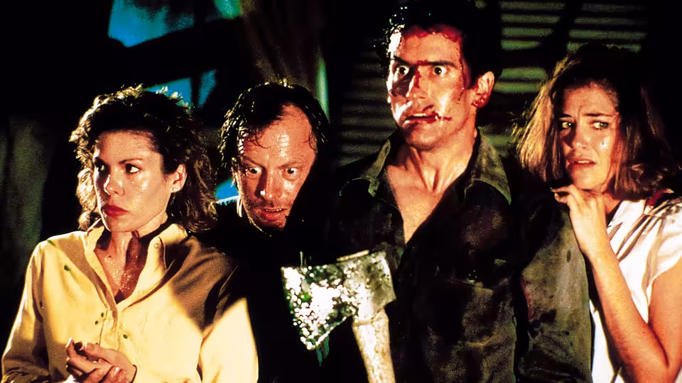 Ash (Bruce Campbell) stands with three others, axe in hand