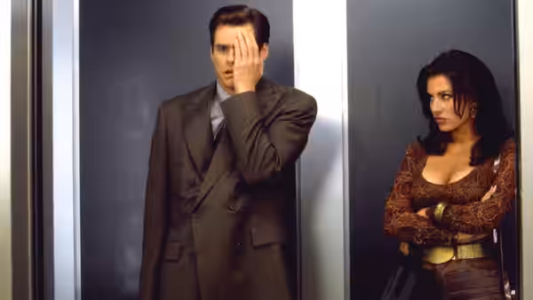Fletcher Reede (Jim Carrey) covering his face beside a woman in elevator