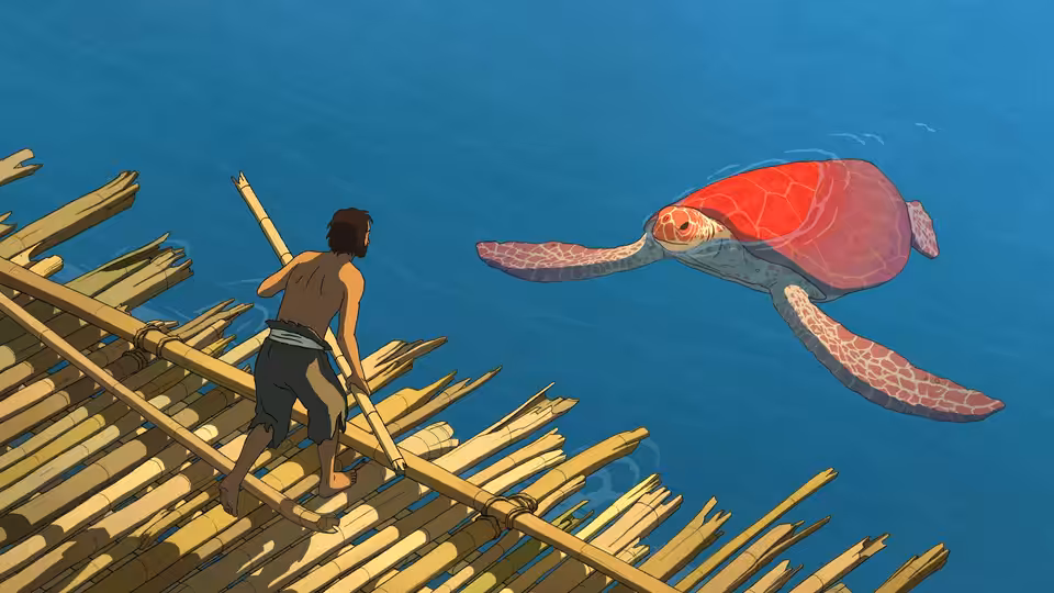 A man stands on a wooden raft facing a large red turtle in the sea