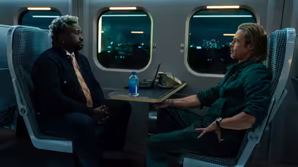 Ladybug (Brad Pitt) and Lemon (Brian Tyree Henry) seated facing each other on a night train