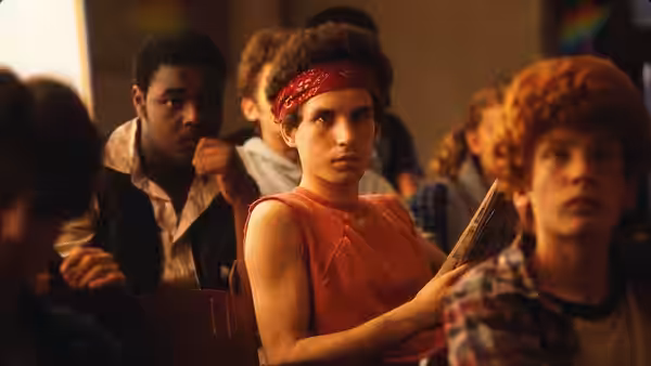 A young woman in a red bandana sits among students in class