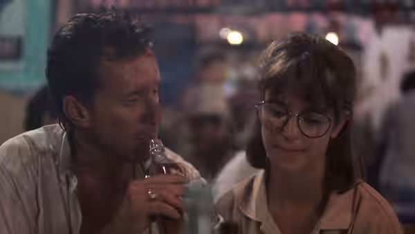 Richard Boyle (James Woods) drinks beside Cathy Moore (Cynthia Gibb) at a crowded bar