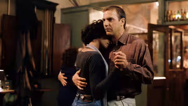 Frank Farmer (Kevin Costner) embraces Rachel Marron (Whitney Houston) inside a home