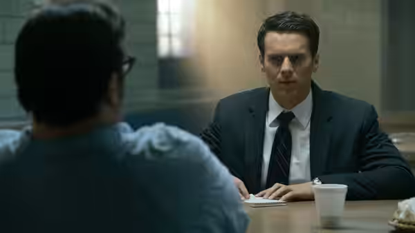 Holden Ford questioning a man across a table in an interview room