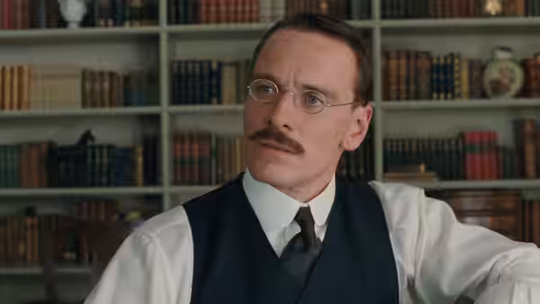 Sigmund Freud (Viggo Mortensen) sits before bookshelves with a thoughtful gaze