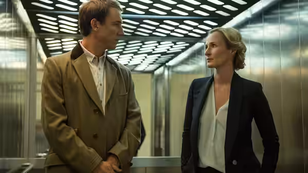 A man and a woman standing face to face inside an elevator