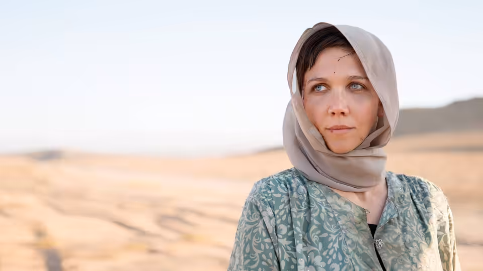 Nessa Stein (Maggie Gyllenhaal) standing in a desert wearing a headscarf